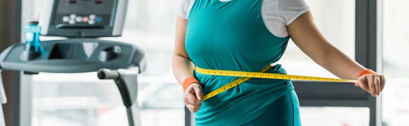 Chica midiendo su vientre ,nutrición y perdida de peso